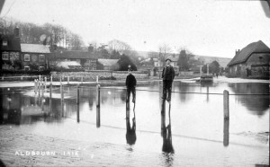Photograph of The Pond looking towards South Street, boys on stilts in the flooded area around the pond - January 1915